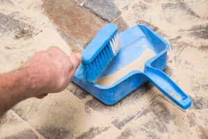 man cleaning patio pavers with a brush