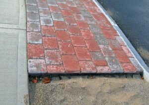 Sidewalk made with brick pavers with edge restrains installed on the perimeter