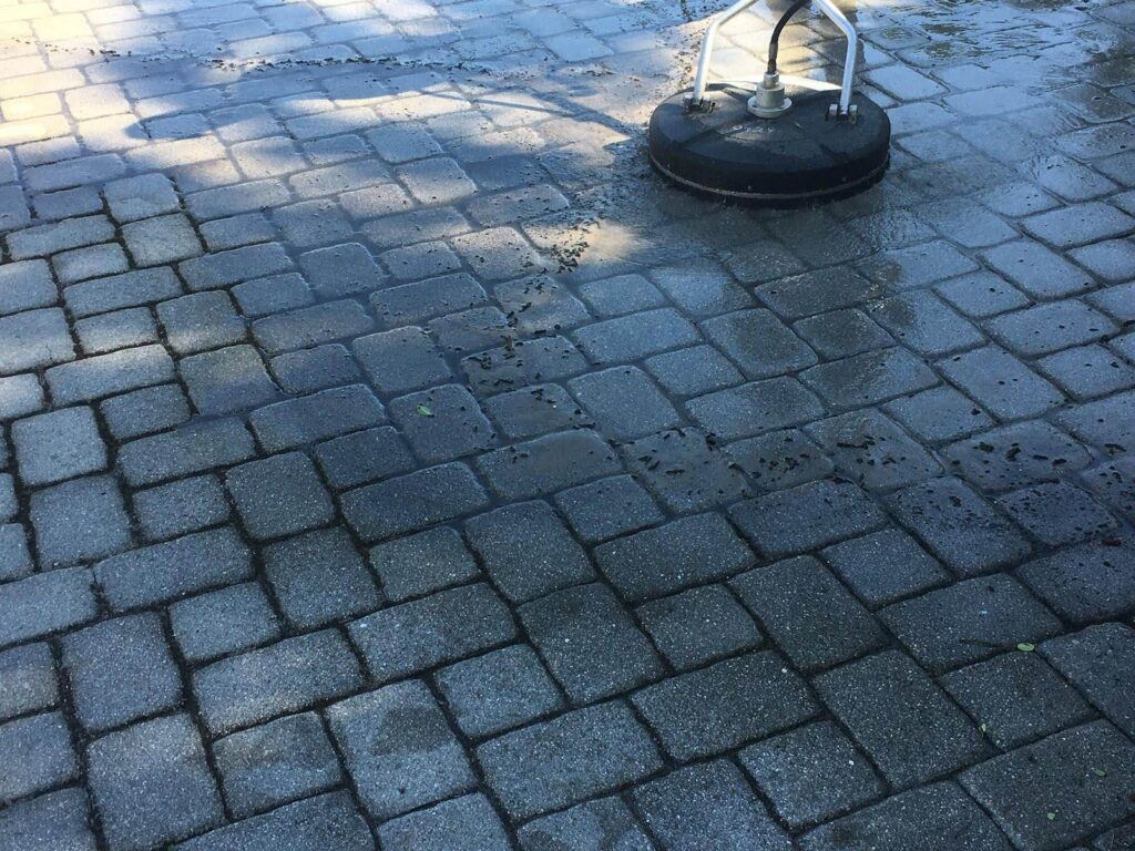 Paver patio being cleaned by a pressure washer