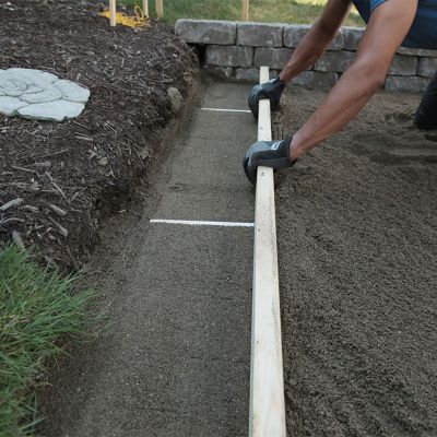 Sand being screed. Detail of the metal tubbings.