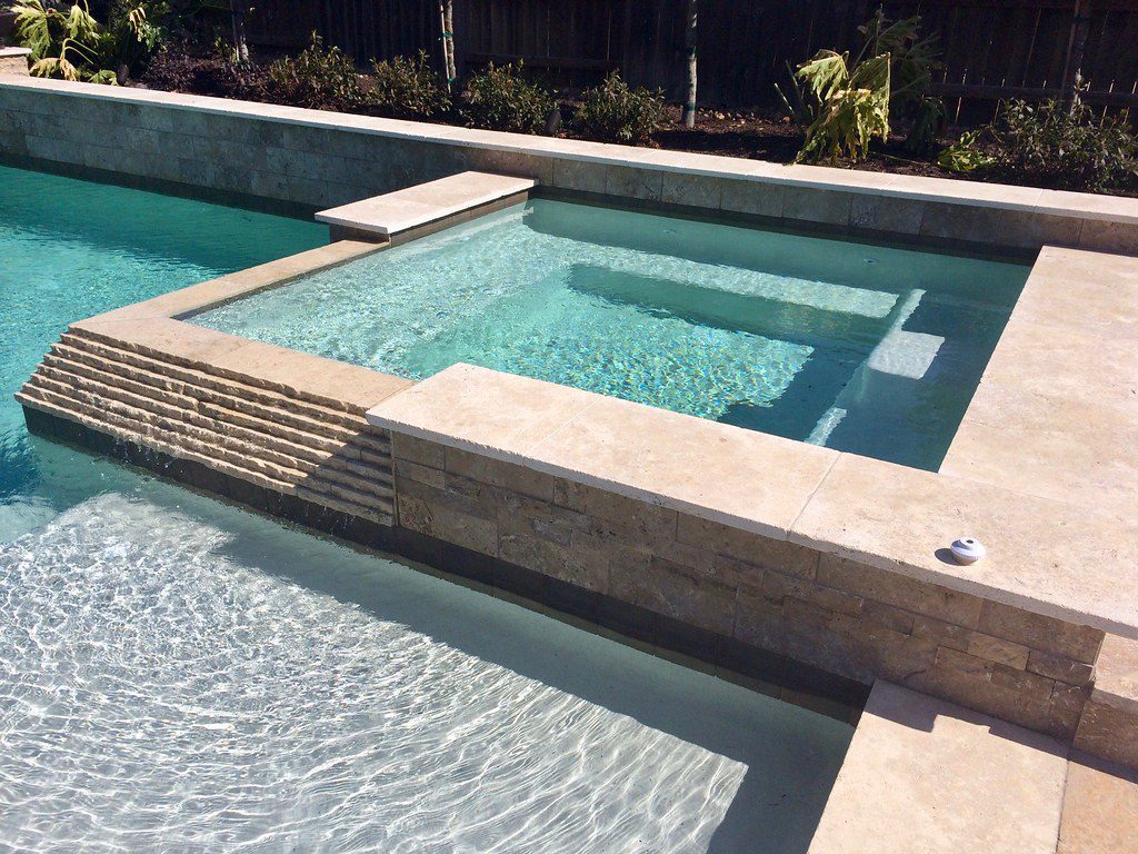 Pool area surrounded by travertine pavers.