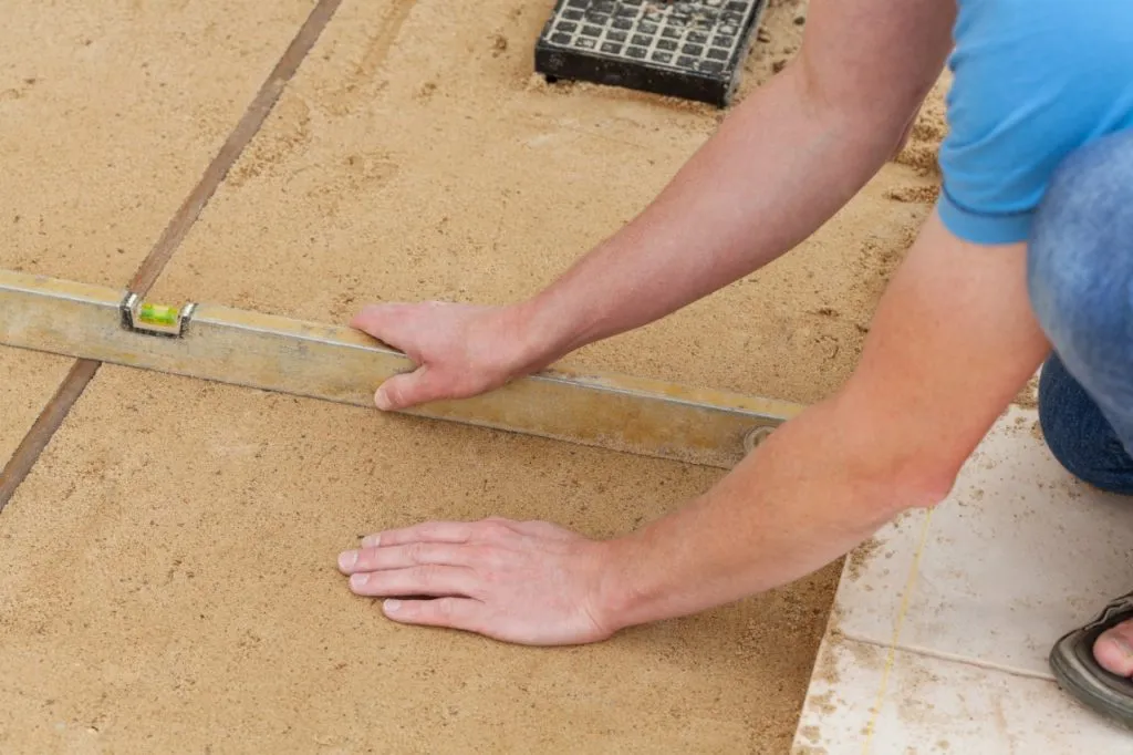 man leveling ground with a bubble level
